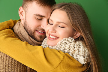 Wall Mural - Portrait of happy couple in winter clothes on color background