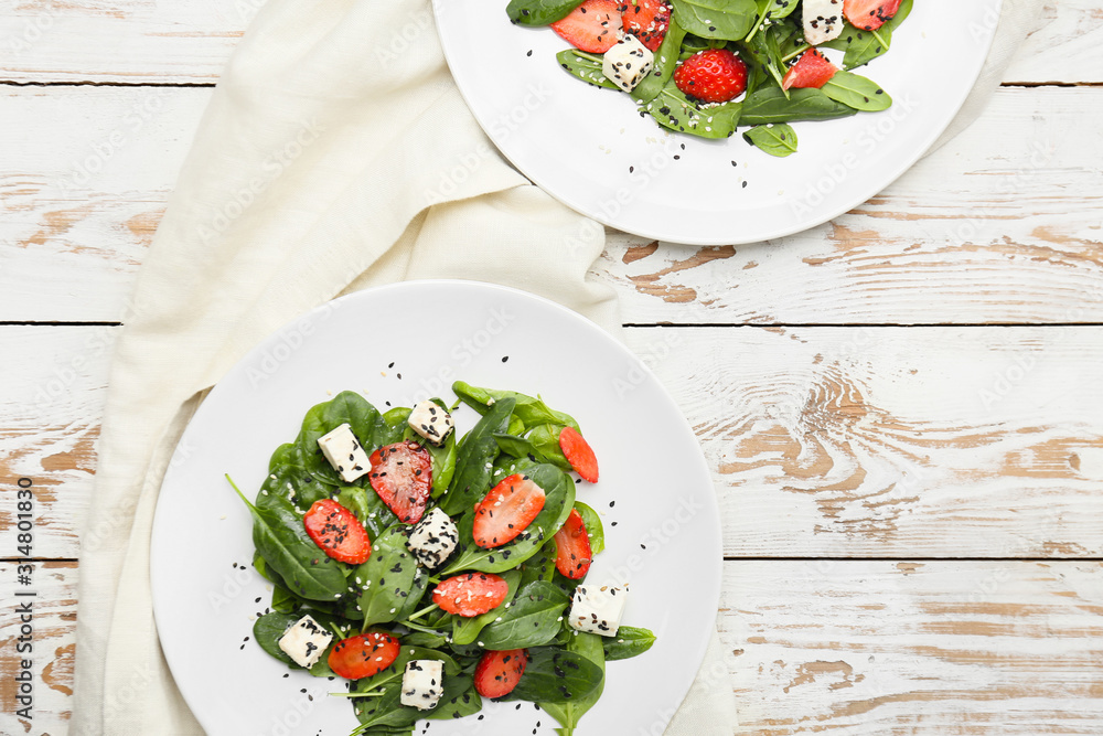 Plates with tasty salad on wooden background