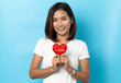 © suriya - Love and valentines day, asian girl holding red heart shape isolated on blue background