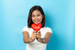© suriya - Love and valentines day, asian girl holding red heart shape isolated on blue background