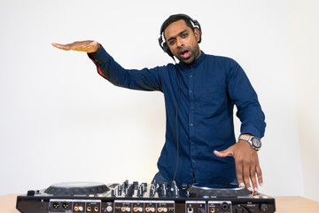 Wall Mural - Male DJ playing music on white background