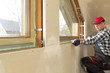 © artursfoto - handyman making measurements for window sill for new installed pvc windows in a new build attic