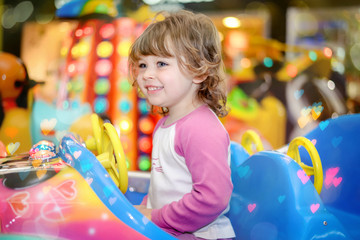 Wall Mural - cute little girl in a merry-go-round