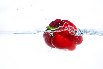 Sweet pepper in the water splashes, the yellow Sweet pepper on a white background.