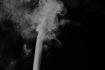 White smoke on a black background. Texture of smoke. Clubs of white smoke on a dark background for an overlay