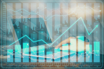 Double exposure of stock market graph with man working on laptop on background. Concept of financial analysis.