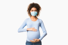 Afro pregnant woman in protective mask against flu and viruses