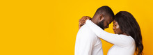 Happily Married Black Couple Hugging Over Yellow Background