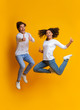 © Prostock-studio - Excited Multiracial Couple Jumping And Gesturing Thumbs Up, Having Fun Together