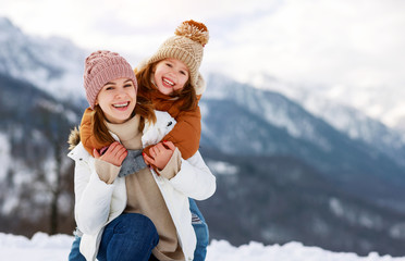 Canvas Print - happy family mother and child playing on winter walk