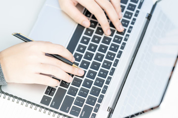 Woman working at home office using laptop searching web, browsing information