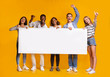 © Prostock-studio - Happy smiling group of students standing together with white placard
