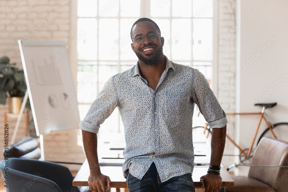 Portrait of smiling african American employee posing in office - obrazy, fototapety, plakaty 