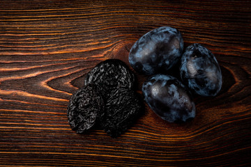 Wall Mural - Fresh plum and prune on dark wooden background.