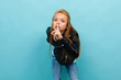 © Ivan Traimak - Caucasian teenager girl in black jacket and jeans want to silence isolatedd on blue background
