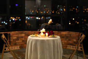 served table with food and burning candles in restaurant interior