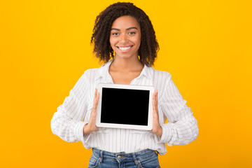 Smiling black woman showing blank computer screen