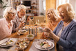 © Drazen - Group of happy senior friends having fun at dining table.