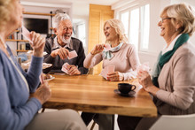 Cheerful Senior Friends Having Fun While Playing Cards Together.