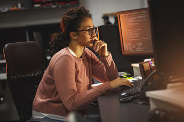 female programmer working working late at night in her office.