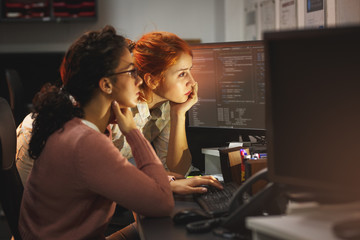 two female programmers working on new project.they working late at night at the office.