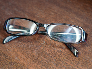 Old man plastic glasses on old wooden floor. Close up and selective focus of senior glasses.