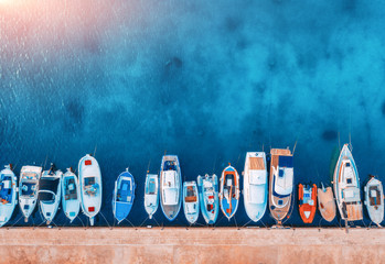 Wall Mural - aerial view of the boats and yachts on tropical sea coast at sunset in summer. colorful landscape wi