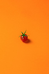 Poster - food background. Fresh red cherry tomato or sweet girl, lying alone on a colored lava background, vertical phone orientation