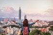 Young woman traveler looking beautiful cityscape at sunset in Taipei, Travel lifestyle concept