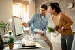 © Drazen - Two colleagues cooperating while using desktop PC in the office.