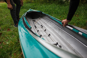 The process of assembling and repairing kayaks: metal skeleton, PVC skin, wooden and aluminum frames. Male hands assemble the canoes and paddle boating.