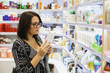 © Northern life - A cute young woman with a cosmetic product in her hands in a cosmetics store.
