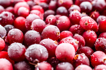 Close up frozen cranberries in a wooden bowl. Selective focus. Top view