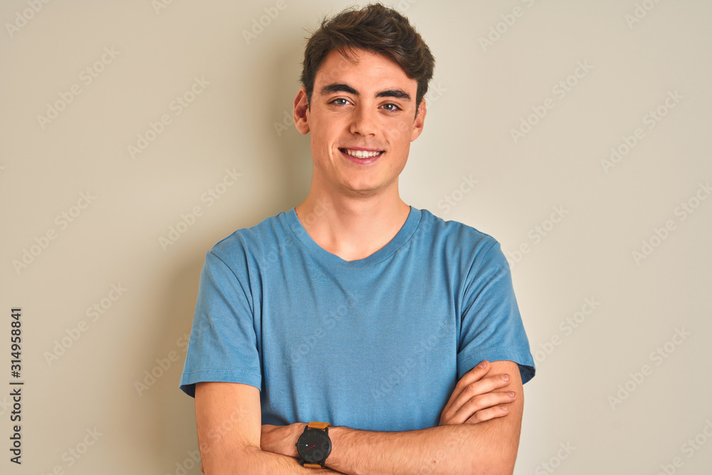 Teenager boy wearing casual t-shirt standing over isolated background happy face smiling with crossed arms looking at the camera. Positive person. - obrazy, fototapety, plakaty 