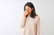 © Krakenimages.com - Beautiful chinese woman wearing turtleneck sweater standing over isolated white background tired rubbing nose and eyes feeling fatigue and headache. Stress and frustration concept.