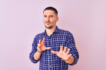 Poster - Young handsome man standing over isolated background disgusted expression, displeased and fearful doing disgust face because aversion reaction. With hands raised. Annoying concept.