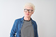© Krakenimages.com - Young albino blond man wearing denim shirt and glasses over isolated white background smiling looking to the side and staring away thinking.
