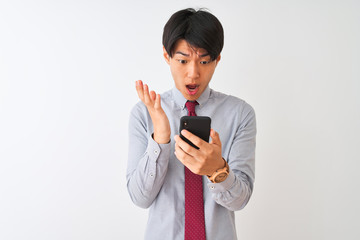 Wall Mural - Chinese businessman wearing tie using smartphone standing over isolated white background very happy and excited, winner expression celebrating victory screaming with big smile and raised hands