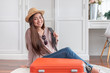 © weedezign - Young asian woman traveler prepare cloth and stuff into orange suitcase for holiday vacation at home.backpacker travel concept
