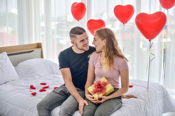 Love Couple giving gift box in bedroom happiness in love Valentine's day concept