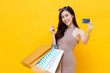 © Atstock Productions - Beautiful smiling Asian woman with shopping bags showing credit card