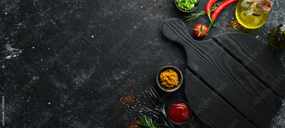 Dark cooking banner. Vegetables and spices on the kitchen table. Top view. Free space for your text. - obrazy, fototapety, plakaty 