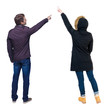 © ghoststone - Back view of couple couple in winter jackets pointing.