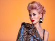 © Valua Vitaly - Beautiful woman with style hairstyle. White woman with bright colored makeup. Fashionable young woman is in the spotted fur coat. Stunning blonde girl. Bright eye makeup. Attractive sexy model poses