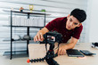 © twinsterphoto - Serious Asian male adjusting camera for video shooting busy hipster preparing for recording vlog at workplace