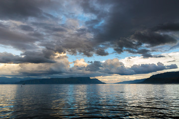 Wall Mural - Tranquil scene of the tropical tourist destination Lake Toba, Sumatra, Indonesia, with beautiful clouds and reflection