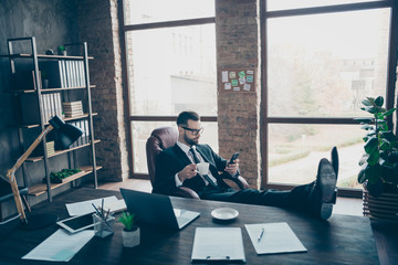 Canvas Print - Profile photo of handsome business guy holding telephone writing corporate email message drink coffee relaxing wear specs black blazer shirt pants tie suit sitting chair office indoors