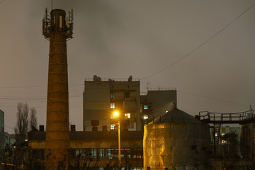 Wall Mural - Photography of the small town Bryansk in Russia in the sunset. Vieww of chimney of Heat station. Lifestyles of small city in cold winter time.