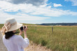 © Olga K - Caucasian woman taking landscape pictures with digital camera