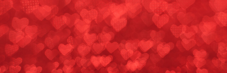 Wall Mural - The bokeh texture in the form of many small hearts on a red background.